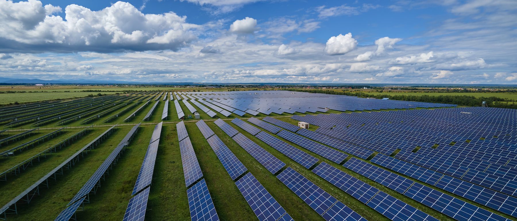 Weitläufige Photovoltaik-Freiflächenanlage in Deutschland unter blauem Himmel