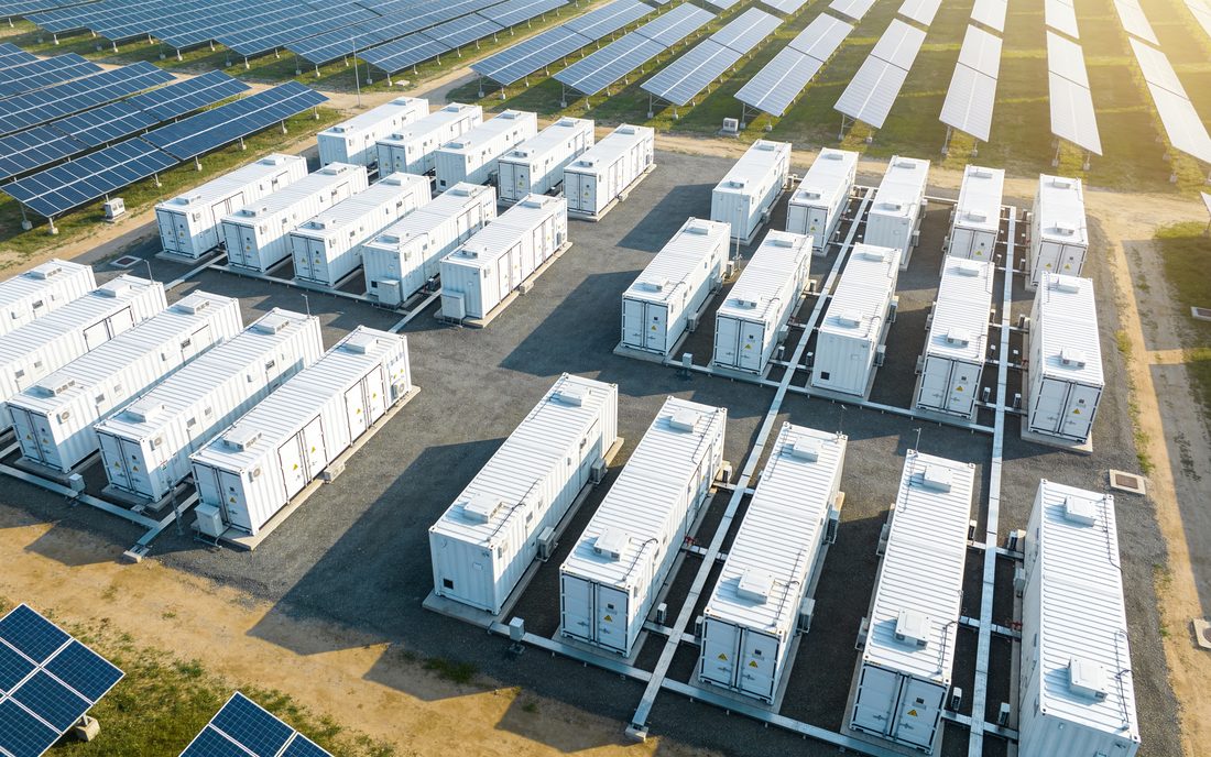 Batteriespeicher-Park in Deutschland: Reihen von Speichercontainern neben einer Photovoltaik-Freifläche